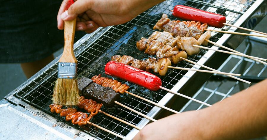 Skewers being marinated on charcoal grill at Filipino BBQ stall
