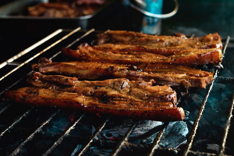 Pork belly slices grilling on charcoal grill